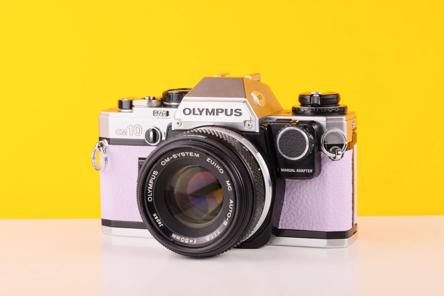 Olympus OM10 35mm SLR Film Camera With Manual Adapter And Olympus Zuiko MC Auto-S 50mm F1.8 Lens In Lilac 1 Olympus OM10 35mm SLR Film Camera With Manual Adapter And Olympus Zuiko MC Auto-S 50mm F1.8 Lens In Lilac