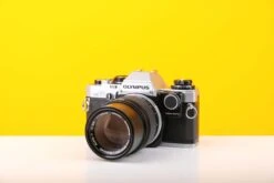 Olympus OM-10 35mm SLR Film Camera With Manual Adapter And Olympus OM-System E.Zuiko Auto-T 135mm F3.5 Lens With Lens Case